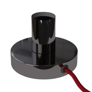 Darc — Une applique murale design en métal noir de forme cylindrique et plate, posée sur une surface lisse, avec un câble rouge visible.