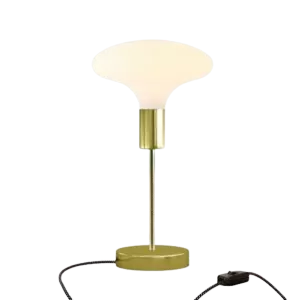 Darc — Lampe de table design avec un abat-jour géométrique blanc, un pied métallique argenté et une base circulaire dorée, posée sur une surface noire
