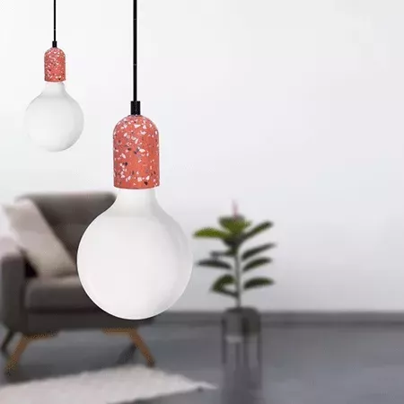 Darc — Deux appliques murales en forme d’ampoules blanches suspendues par des fils noirs. L’une d’elles possède une base décorative en forme de dôme r