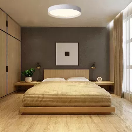 Darc — Une chambre épurée avec un grand lit au cadre en bois clair, une tête de lit en bois épais, deux lampes design sur des tables basses, une plant