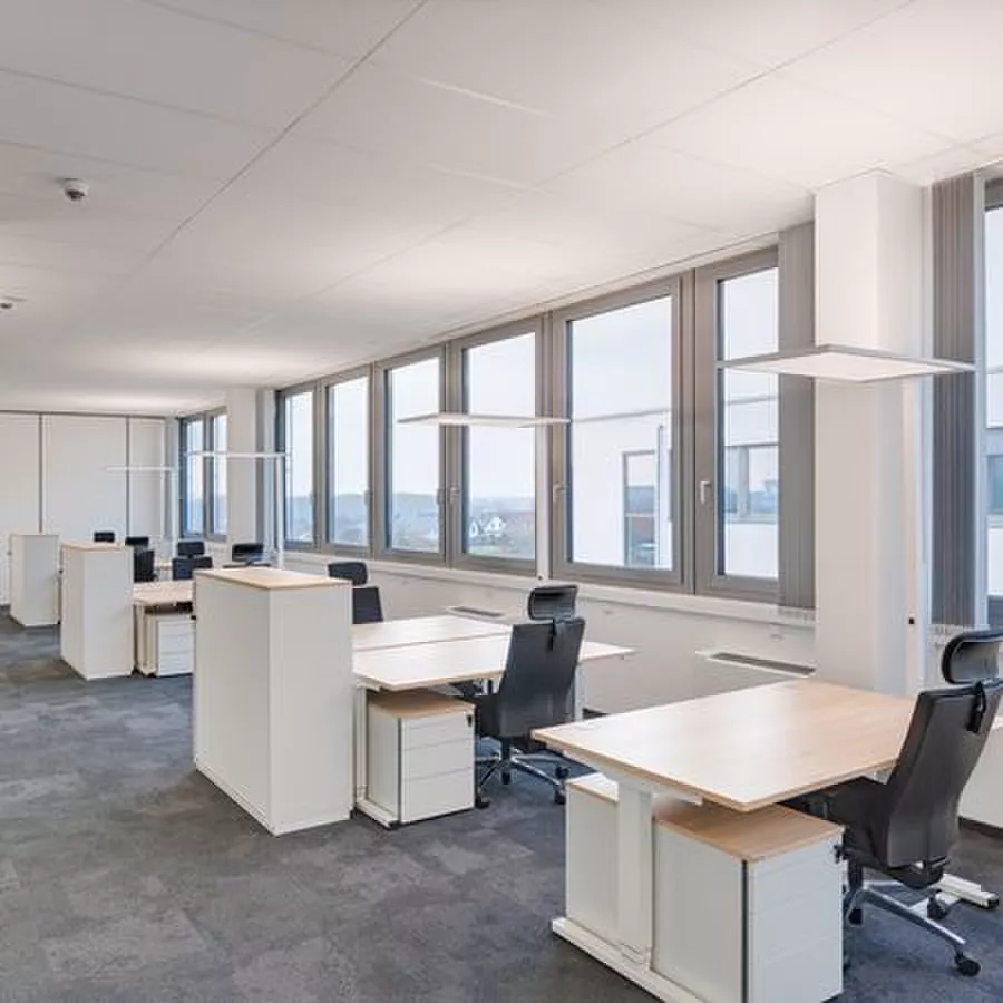 Darc — Salle de travail lumineuse équipée de plusieurs postes ergonomiques, chacun composé d’un bureau blanc, d’une chaise réglable et de rangements i