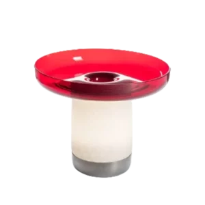 Darc — Une bougie parfumée de forme moderne avec un haut rouge translucide en forme de champignon et une base blanche cylindrique sur un socle métalli