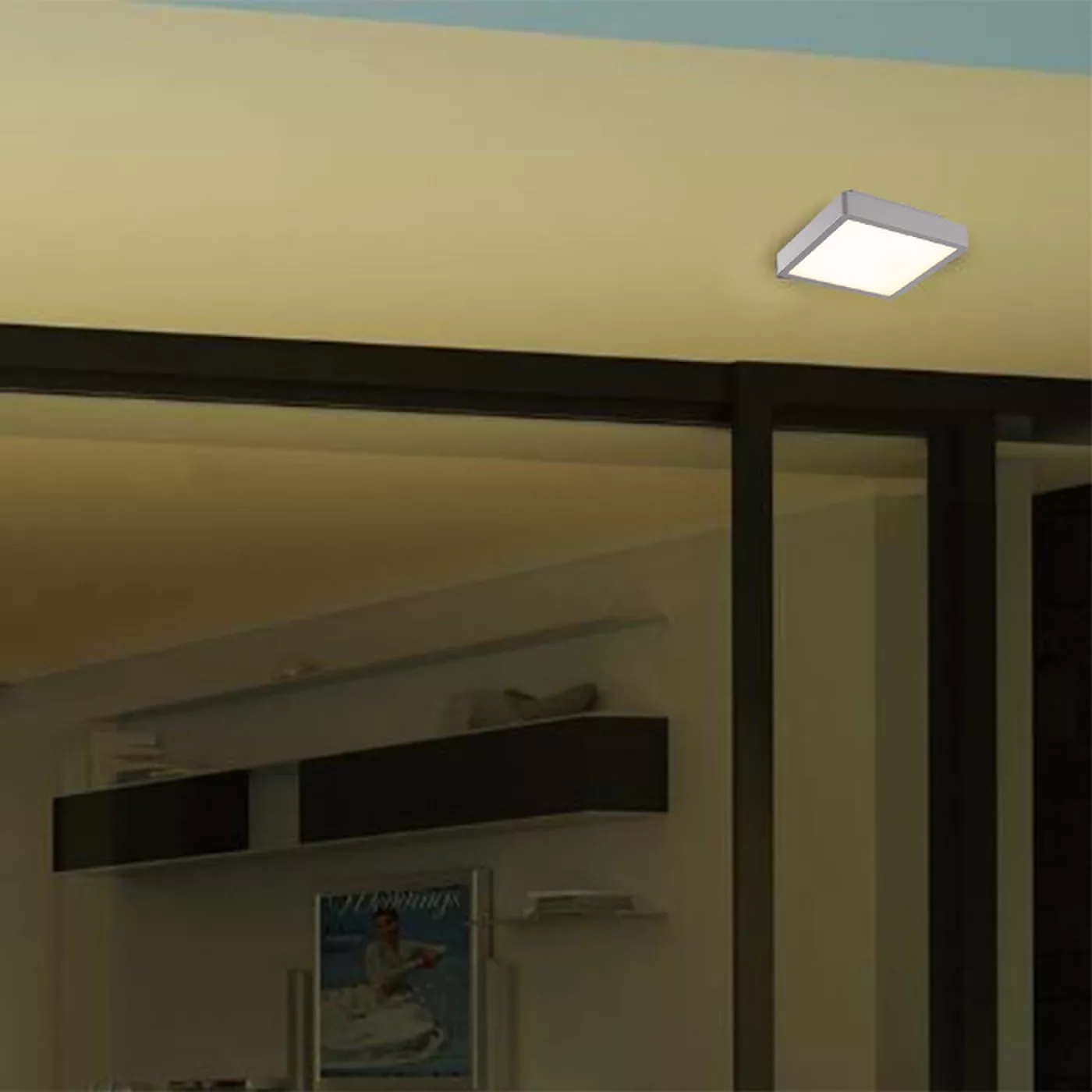 Darc — Un luminaire carré encastré dans un plafond clair, éclairant une étagère noire et une porte vitrée dans un salon épuré.