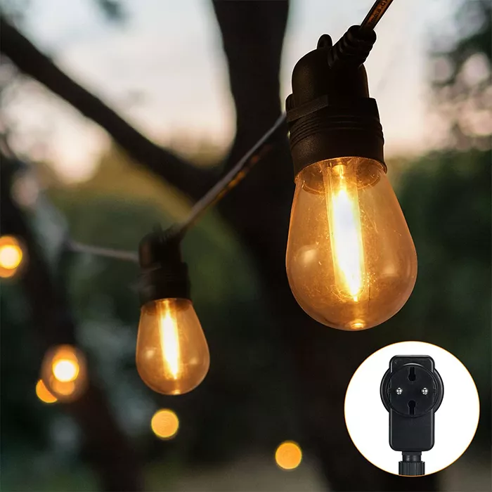 Darc — Une guirlande lumineuse extérieure composée d'ampoules en verre de style vintage, suspendues à une branche sombre, créant une ambiance chaleure