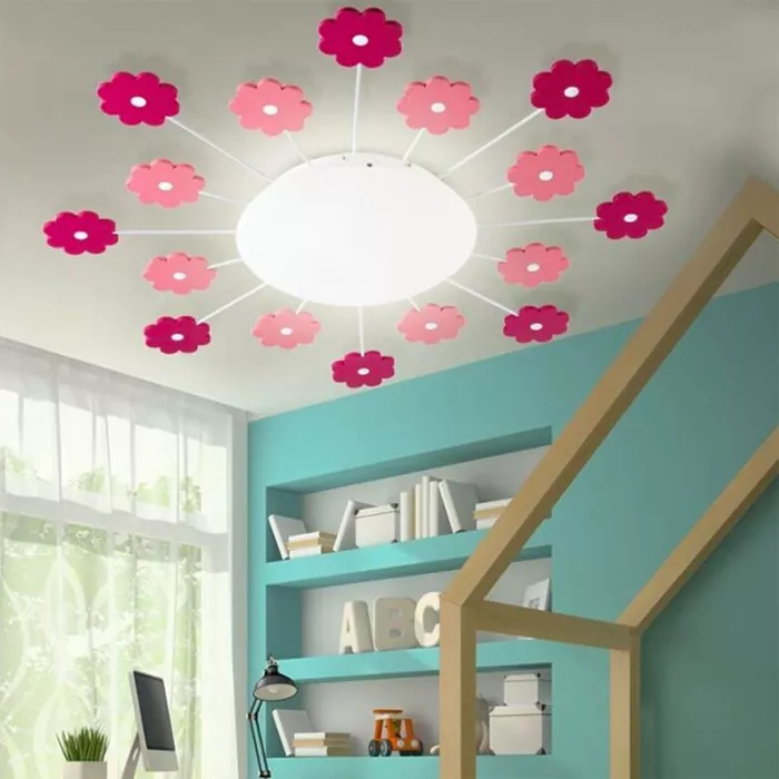Darc — Un plafond lumineux en forme de soleil entouré de douze fleurs en papier translucide, roses et violettes, éclairées par en dessous dans une cha
