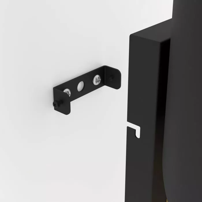 Darc — Un support mural noir fixé sur un mur blanc, conçu pour maintenir une porte coulissante avec deux trous de fixation et une encoche pour un rail