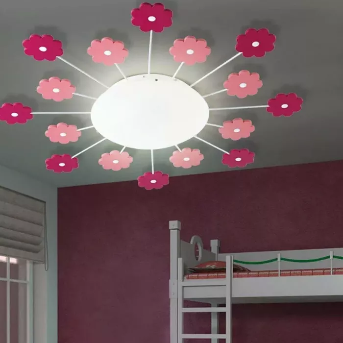 Darc — Un plafonnier suspendu en forme de soleil entouré de douze fleurs en papier ou tissu, alternant entre rose vif et rose pâle, éclairant une cham