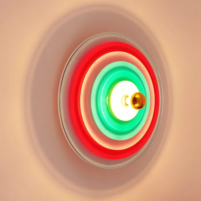 Darc — Une cible circulaire translucide aux dégradés de couleurs rouge et vert, entourant une lumière centrale dorée qui irradie comme une aurore