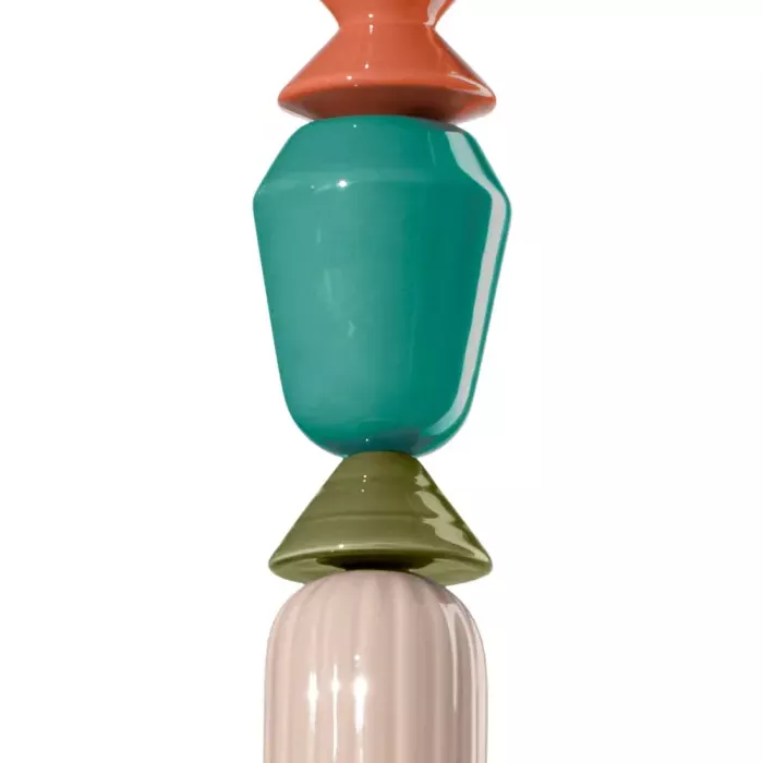 Darc — Une bougie décorative en forme de nœud de lariat composée de trois éléments superposés : une base rose pâle, un élément central vert turquoise
