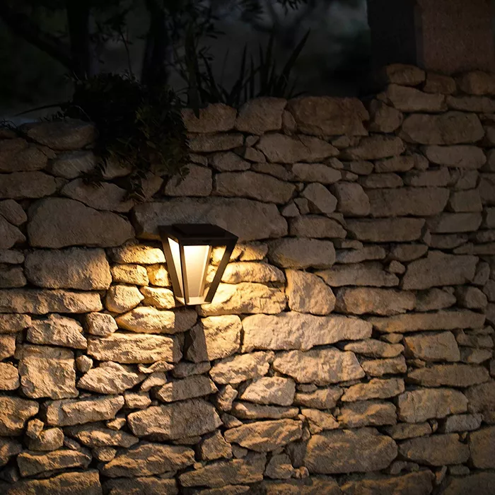 Darc — Un projecteur mural moderne encastré dans un mur en pierres naturelles, éclairant une zone avec une lumière douce et chaude pour un effet esthé
