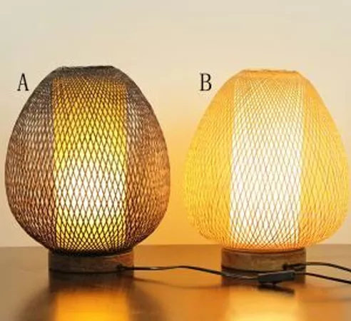 Darc — Deux lampes de table design en forme ovale avec un treillis métallique fin et lumineux, diffusant une lumière douce et chaude, posées sur une s