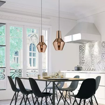 Darc — Une pièce lumineuse équipée d’une table noire entourée de quatre chaises assorties, éclairée par deux lustres hexagonaux dorés suspendus au pla
