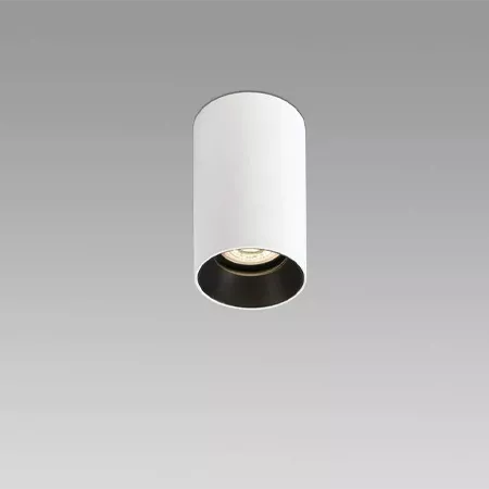 Darc — Un luminaire encastré blanc cylindrique avec un rebord noir autour de la source lumineuse, projetant une lumière douce et uniforme.