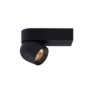 Darc — Un projecteur encastré noir avec une lumière dorée et douce émanant de son extrémité, monté sur un fond noir uniforme.