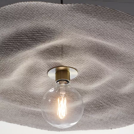 Darc — Applique murale en tissu gris texturé avec une ampoule à filament visible, suspendue par un support doré et métallique, diffusant une lumière d
