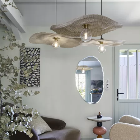 Darc — Un luminaire suspendu en forme de vague avec trois ampoules à lumière chaude, installé dans un salon moderne aux murs clairs, entouré d’un miro
