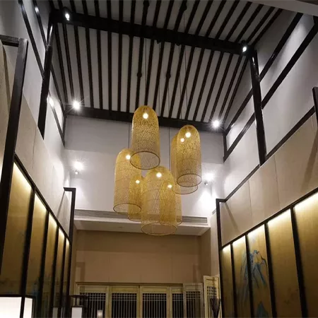 Darc — Quatre suspensions en métal doré et transparent, disposées en groupe au plafond d’un espace intérieur contemporain, éclairant une pièce avec de