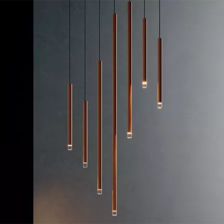 Darc — Six appliques suspendues en forme de cylindres en bois foncé avec des ampoules LED intégrées, accrochées à des fils fins contre un mur gris fon