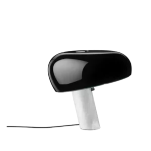 Darc — Un projecteur design au corps noir et blanc, de forme ovale et élancée, posé sur une base fine et transparente, avec un angle légèrement inclin