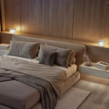 Darc — Un lit cosy avec une tête de lit intégrée en tissu gris clair, entouré de deux lampes design allumées de chaque côté, sur un sol en bois clair