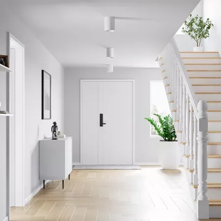 Darc — Une entrée lumineuse et épurée avec un sol en carrelage beige clair. À gauche, un meuble bas sous un miroir et une petite statue. Au centre, un