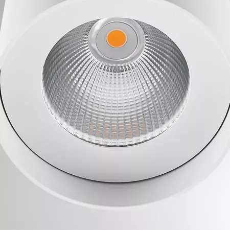Darc — Un projecteur LED encastrable de couleur blanche, avec un diffuseur texturé et une lumière orange chaude visible au centre, intégré dans un pla