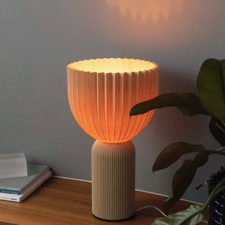 Darc — Une lampe design en forme de vase lumineux, composée d’un pied en bois texturé et d’un abat-jour en tissu translucide diffusant une lumière cha