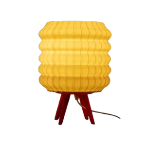 Darc — Luminaire jaune en forme de nid d'abeille posé sur un support rouge en forme de trépied, avec une texture hexagonale distinctive